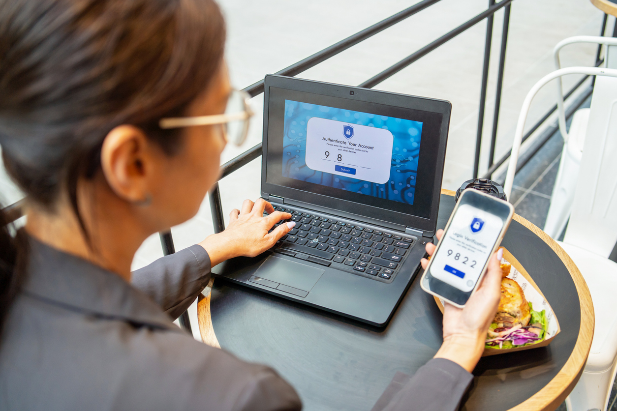 Cybersecurity login method using 2FA Two-Factor Authentication. Woman login to laptop using smart phone
