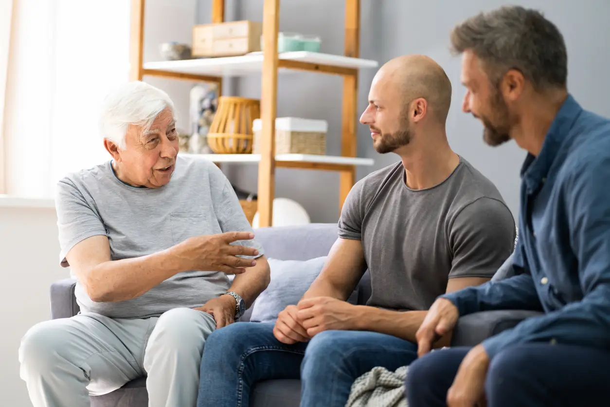 Adult children having a serious conversation with their aging father at home